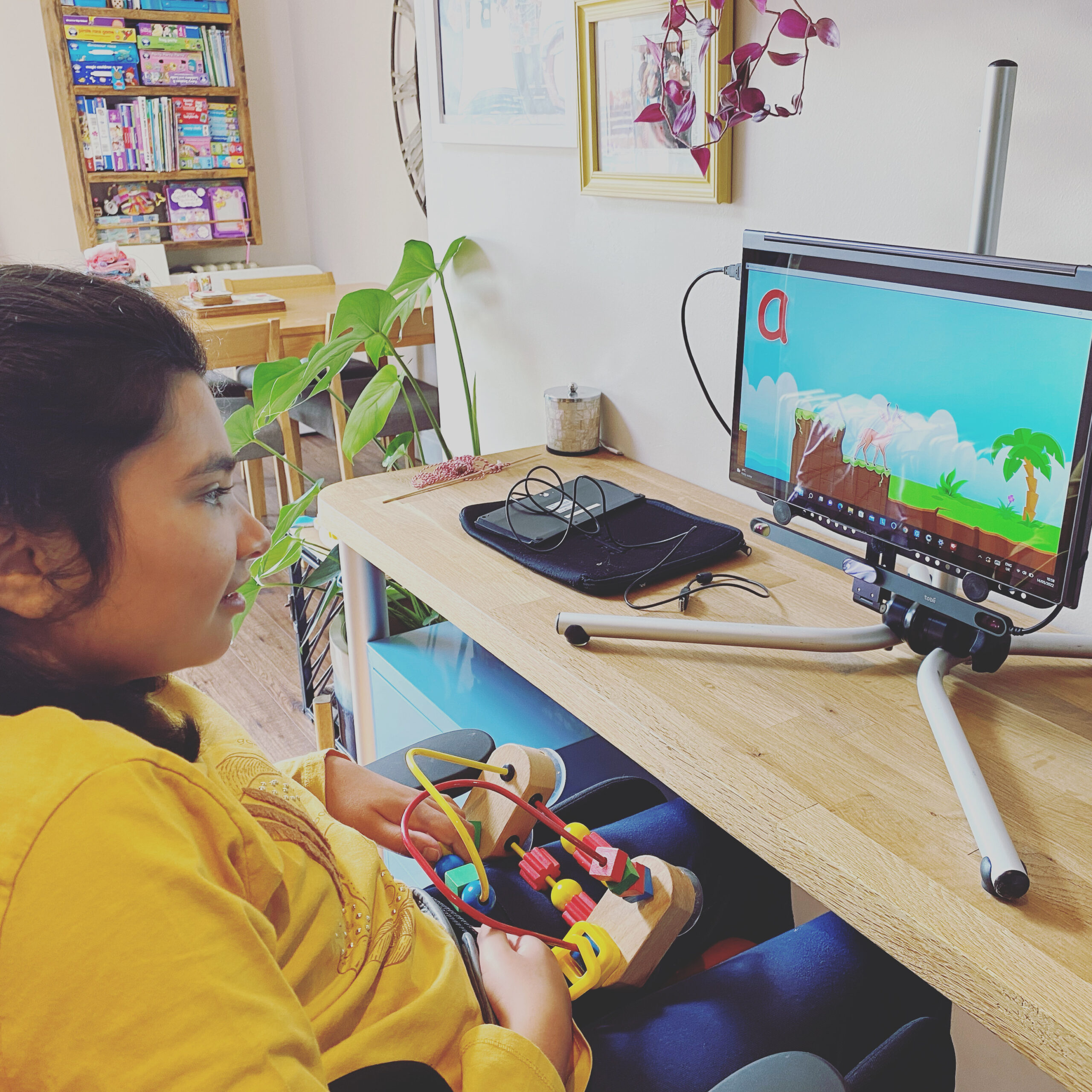 girl sitting in front of a computer using eye gaze